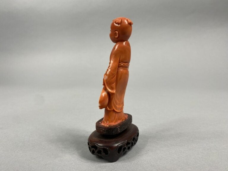 Chine - Sujet en corail sculpté représentant un enfant debout tenant un éventai…