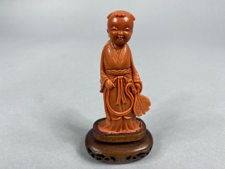 Chine - Sujet en corail sculpté représentant un enfant debout tenant un éventai…