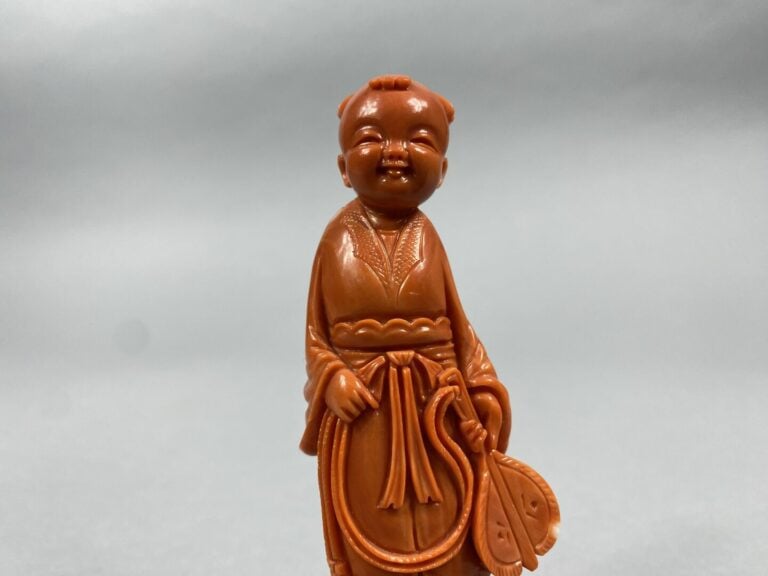 Chine - Sujet en corail sculpté représentant un enfant debout tenant un éventai…