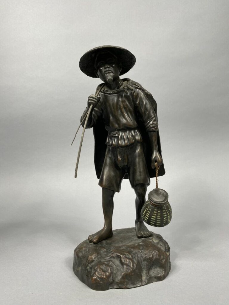 Vietnam - Important sujet en bronze représentant un pêcheur debout tenant un sa…