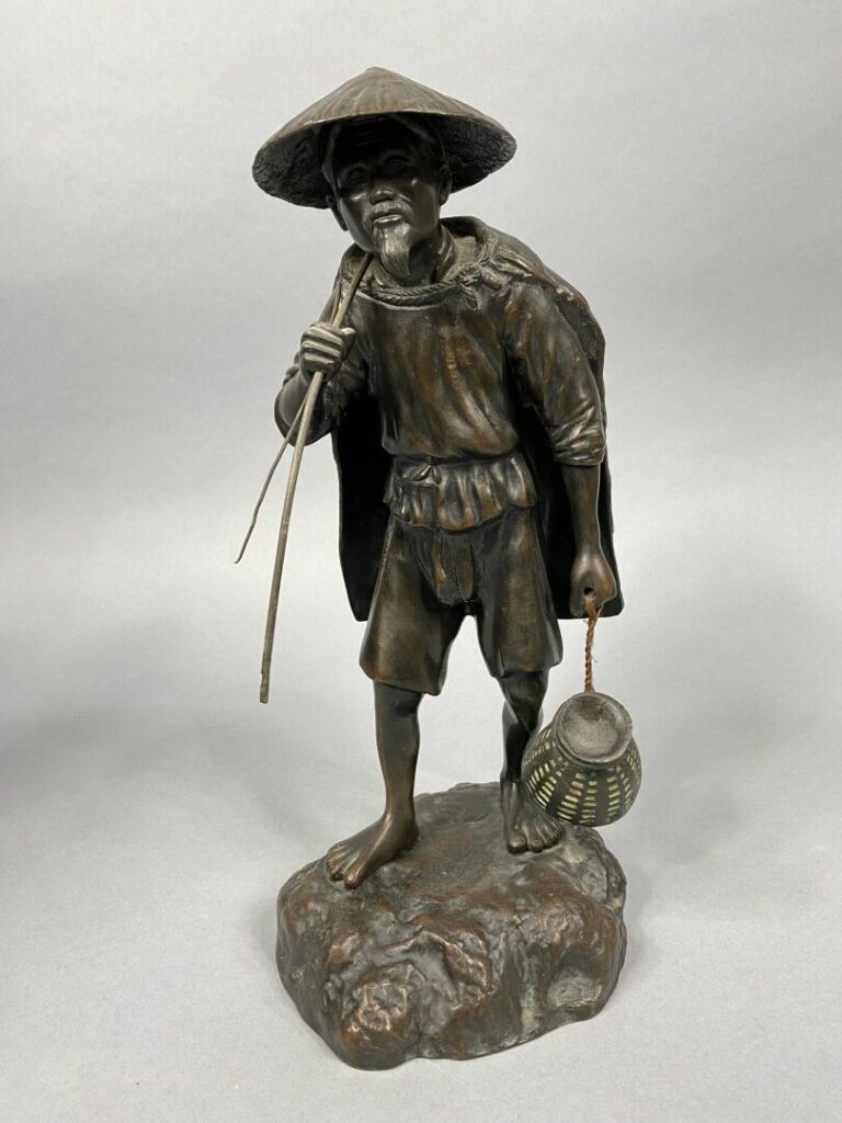 Vietnam - Important sujet en bronze représentant un pêcheur debout tenant un sa…