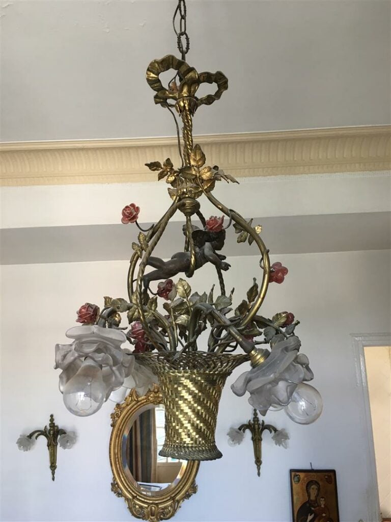 Lustre à quatre lumières à décor d'un panier fleuri surmonté d'un putto, style…