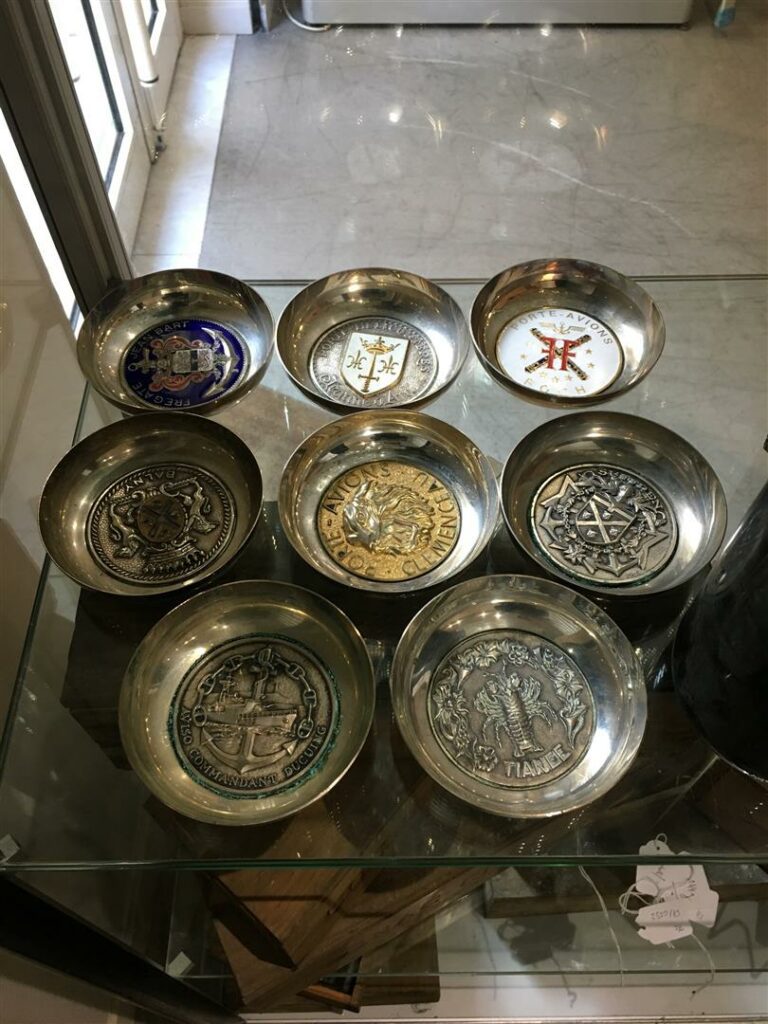 Huit coupes en métal argenté, incrustées de médailles commémoratives de batimen…