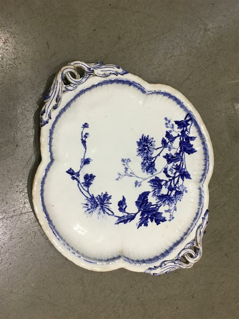 Plat quadrilobé en faience fine, les anses feuillagées en entrelacs, à décor im…