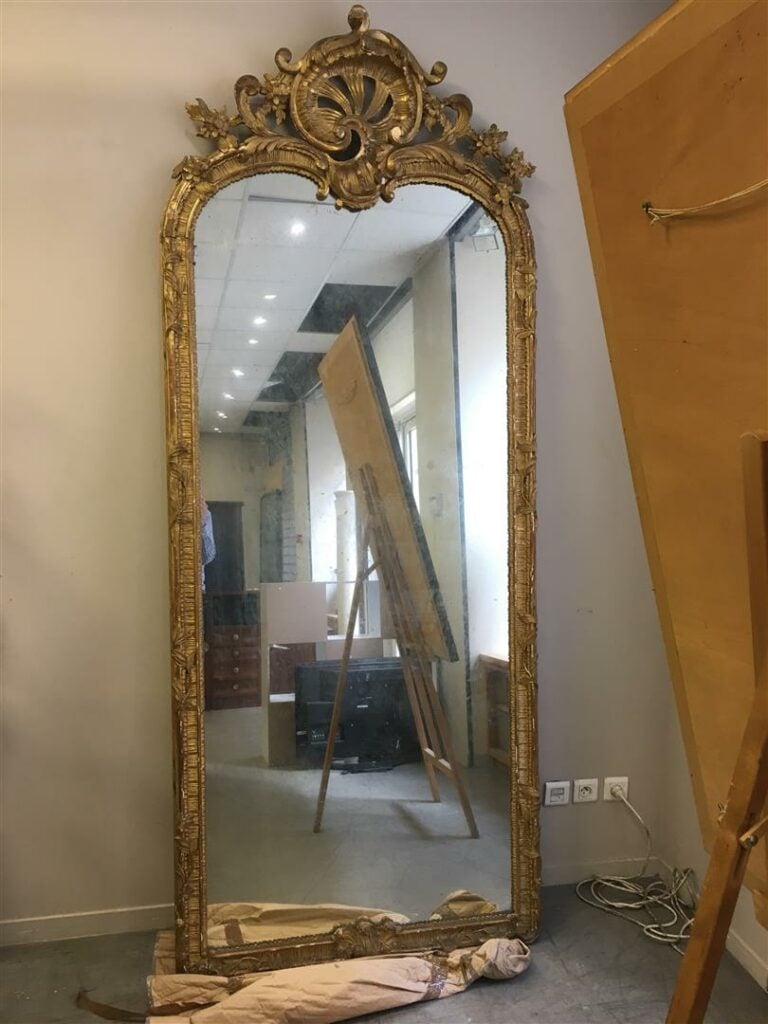 Importante paire de miroirs en bois sculpté, sculpté et doré, le fronton cintré…