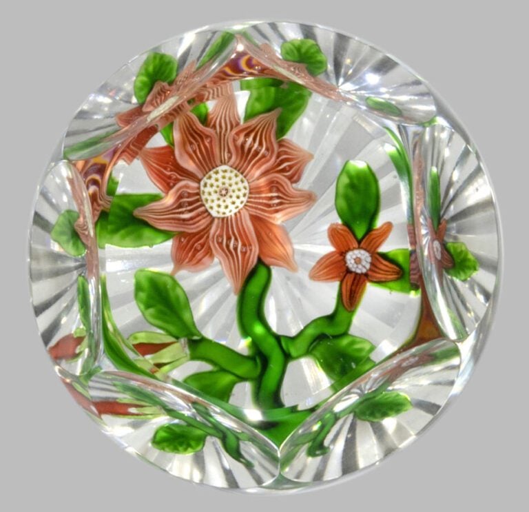 Baccarat. Presse-papiers orné d'une double clématite rose à pétales striés et d…