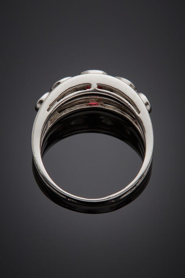 BAGUE en or gris (750‰) ajouré, ornée de trois rubis ronds et deux diamants tai…