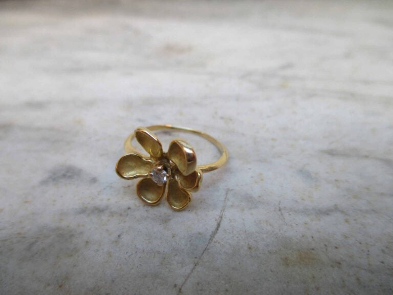 Bague en or jaune 18K (750°/oo) figurant une fleur à six pétales en or lisse et…