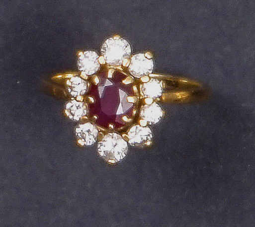 Bague "marguerite" en or jaune 18K (750%o) serti d'un rubis de taille ovale, en…