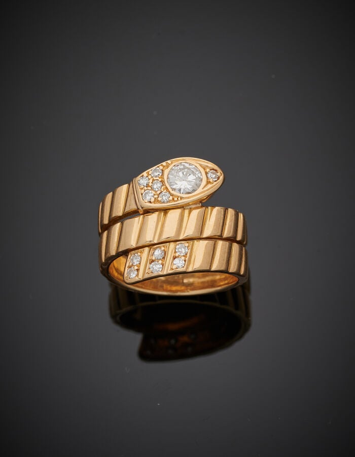 BAGUE « serpent » en or jaune (750‰) godronné, la tête et la queue serti de dia…