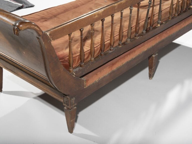 Banquette en acajou et placage d'acajou , les côtés eversés sculptés de têtes d…