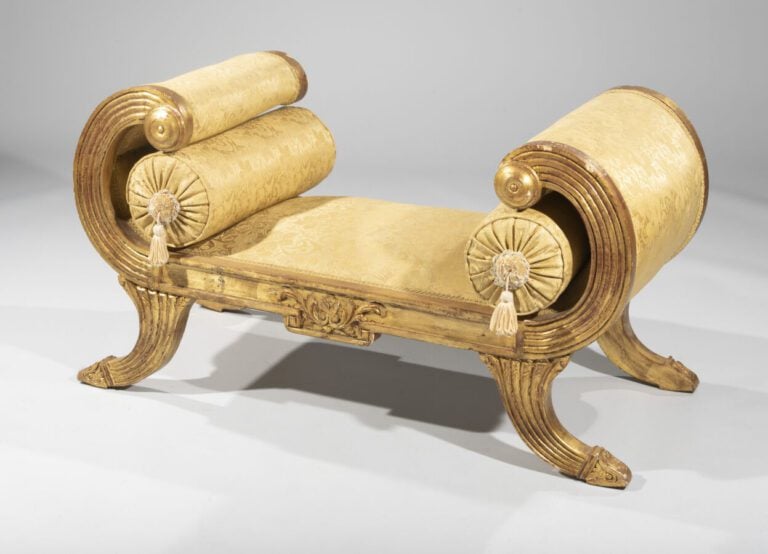 Banquette en bois doré rainuré et sculpté de feuilles d'acanthe à côtés à enrou…