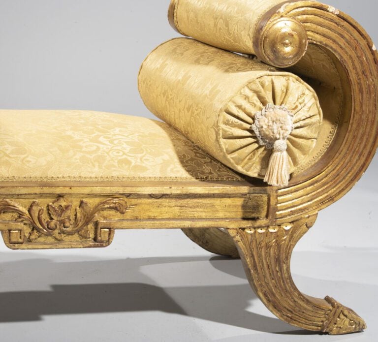 Banquette en bois doré rainuré et sculpté de feuilles d'acanthe à côtés à enrou…