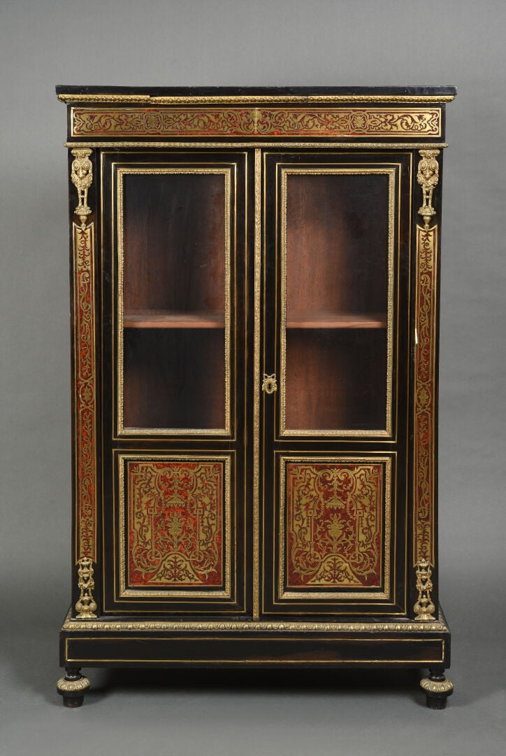 Bibliothèque en bois noirci ouvrant par deux portes partiellement vitrées à déc…