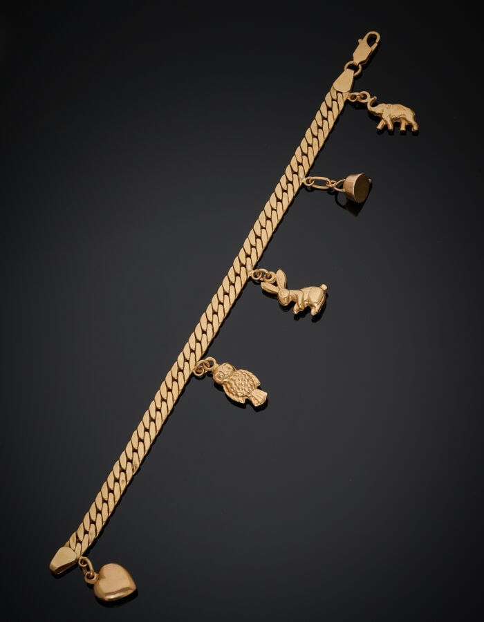 BRACELET en or jaune (750‰) à maille gourmette plate, retenant cinq breloques,…