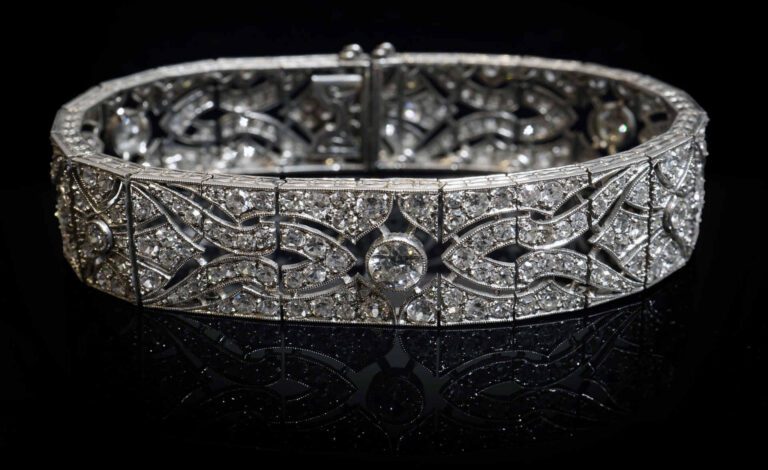 Bracelet ruban articulé en or blanc 18K (750%o) ajouré à décor de méandres sert…
