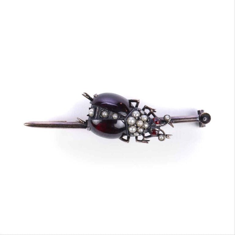 Broche en or et argent ornée d'une coccinelle sur une ligne sertie de grenats c…