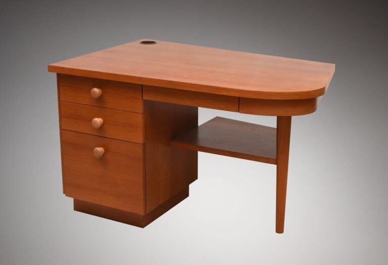 Bureau en bois naturel ouvrant par trois tiroirs dans un caisson et un tiroir e…