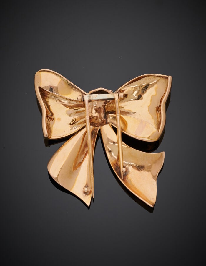 CLIP de CORSAGE « noeud » en or rose (750‰) centré de neuf diamants taillés en…