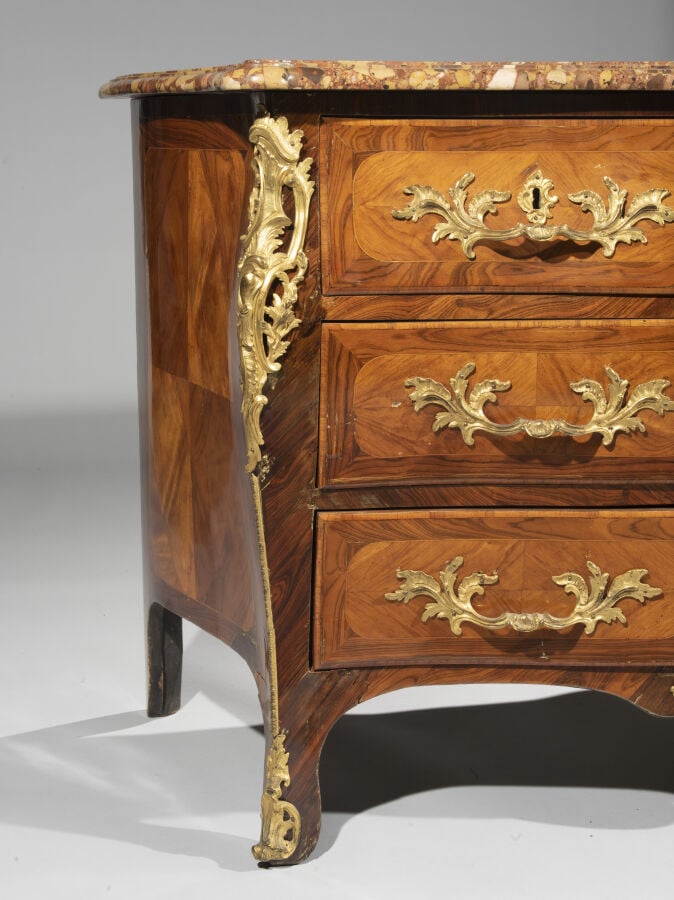 Commode marquetée en quartefeuilles de bois de rose dans des encadrements de bo…