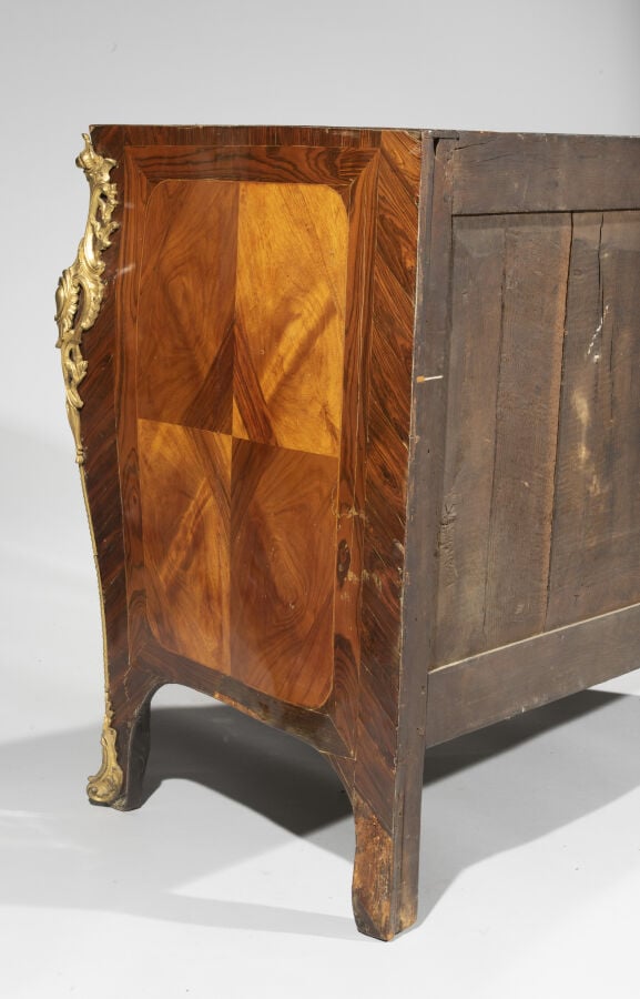 Commode marquetée en quartefeuilles de bois de rose dans des encadrements de bo…