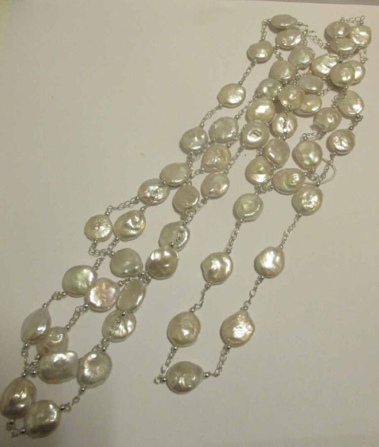 Long sautoir composé de perles d'eau douce baroques plates alternant de chaînet…