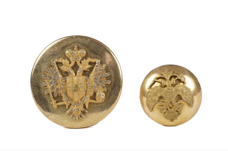 Lot de deux boutons pour habit en métal doré ornés d'aigles impériales, l'un ru…