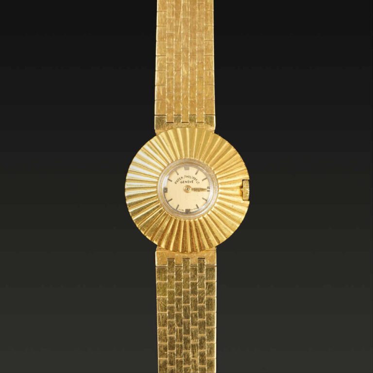 PATEK PHILIPPE - Montre-bracelet de dame en or jaune, le boîtier à motif rayonn…
