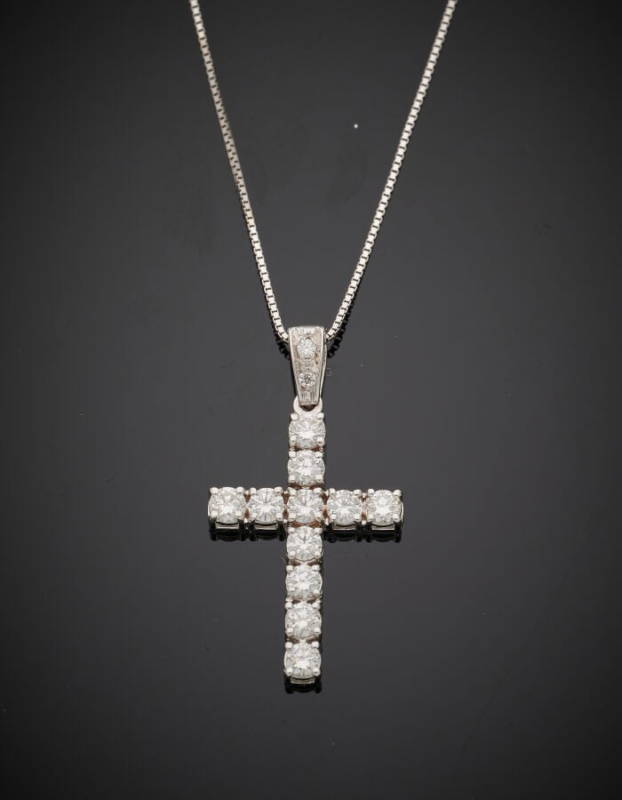 PENDENTIF « croix » et sa chaînette, en or gris (750‰) serti de onze diamants t…
