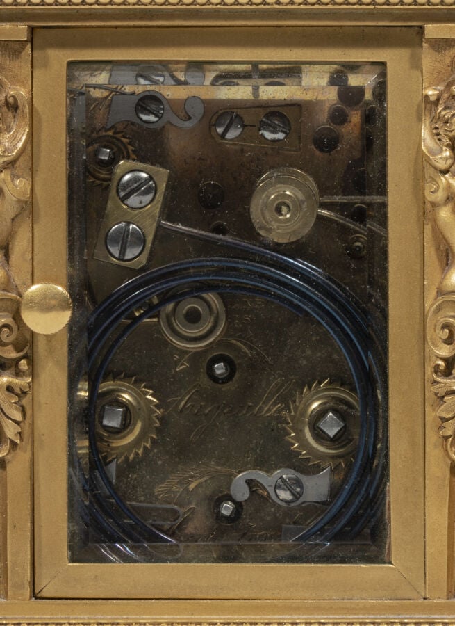 Pendulette en bronze doré , anse mobile ; elle présente aux quatre angles des t…