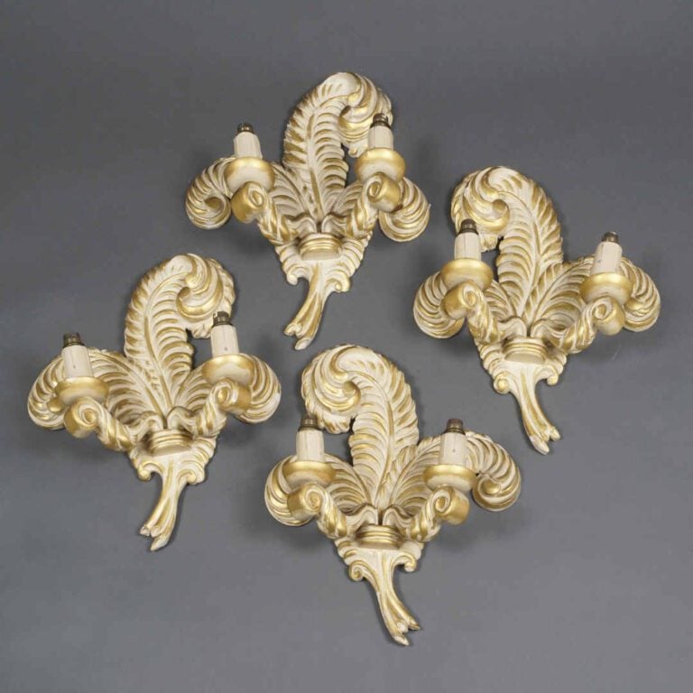 Suite de quatre appliques à deux bras de lumière en bois sculpté laqué crème et…