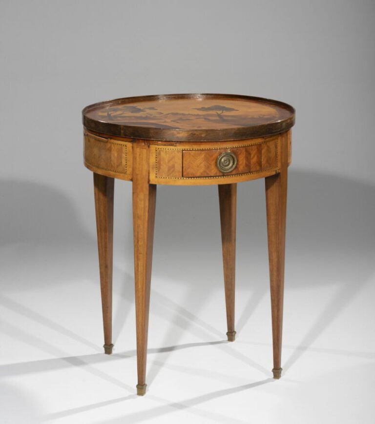 Table bouillotte en bois de placage marqueté à deux tiroirs et deux tirettes. P…