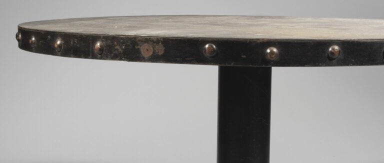 TABLE CIRCULAIRE en fonte laquée noire . La ceinture à ombilics simulant des cl…