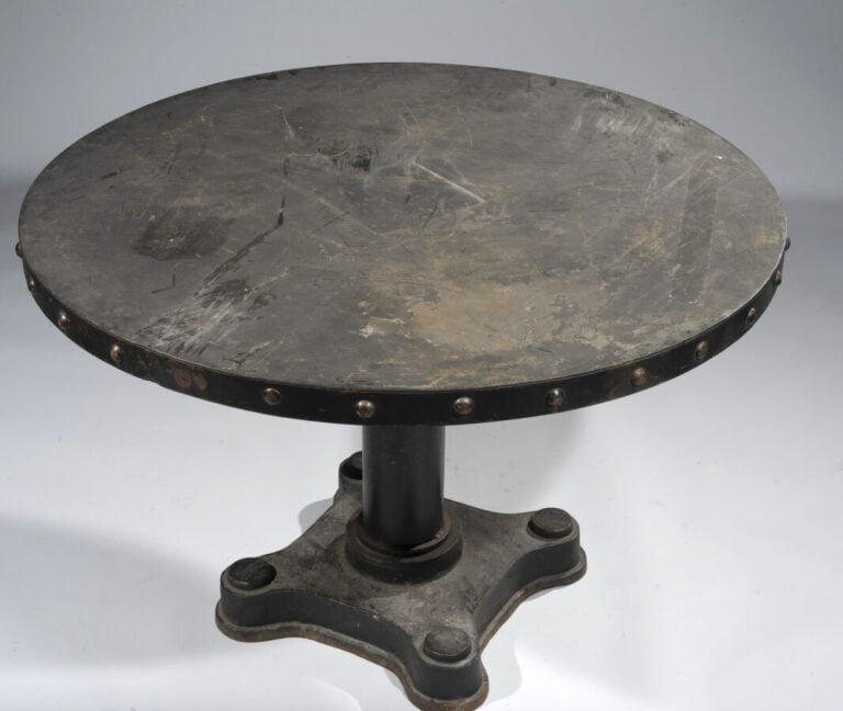 TABLE CIRCULAIRE en fonte laquée noire . La ceinture à ombilics simulant des cl…