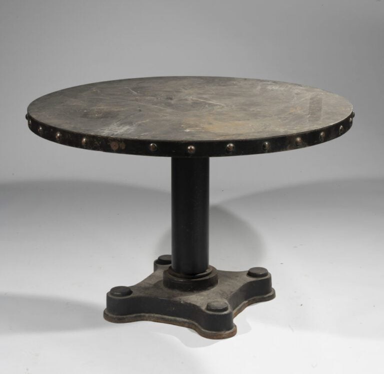 TABLE CIRCULAIRE en fonte laquée noire . La ceinture à ombilics simulant des cl…