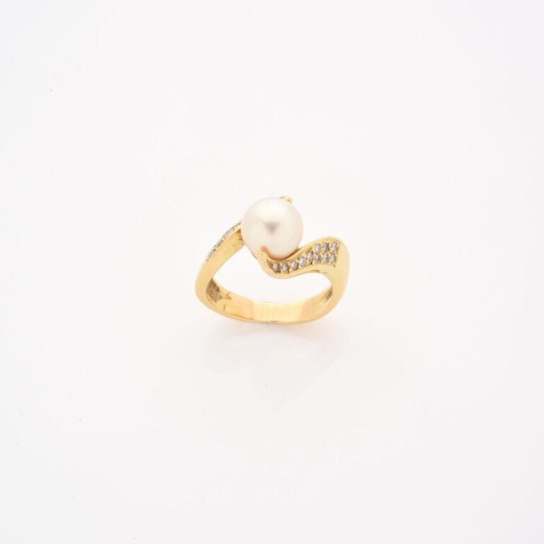 Bague en or jaune (750) ornée d'une perle de culture blanche épaulée de deux li…