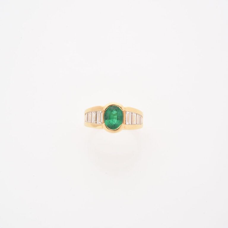Bague jonc en or jaune (750) ornée d'une émeraude de taille ovale facettée, épa…