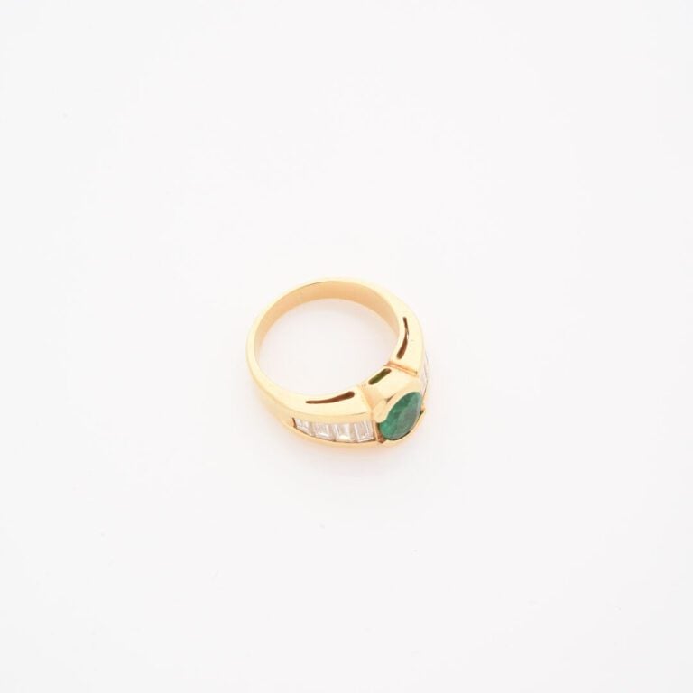 Bague jonc en or jaune (750) ornée d'une émeraude de taille ovale facettée, épa…