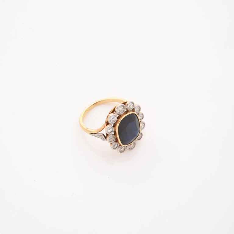 Bague marguerite en or jaune (750) ornée d'un saphir ovale facetté dans un ento…