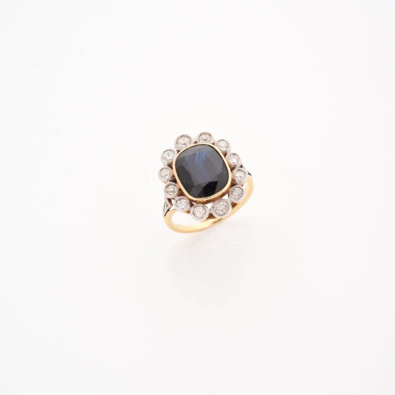 Bague marguerite en or jaune (750) ornée d'un saphir ovale facetté dans un ento…