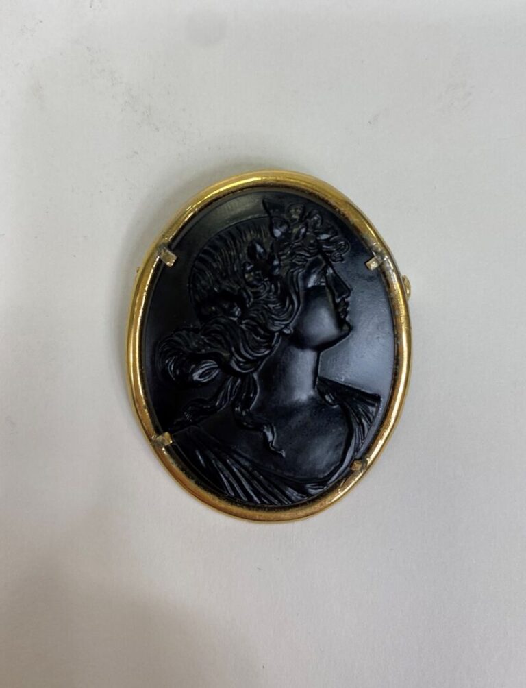 Broche ovale en métal doré ornée d'un camée en onyx à décor de buste féminin de…