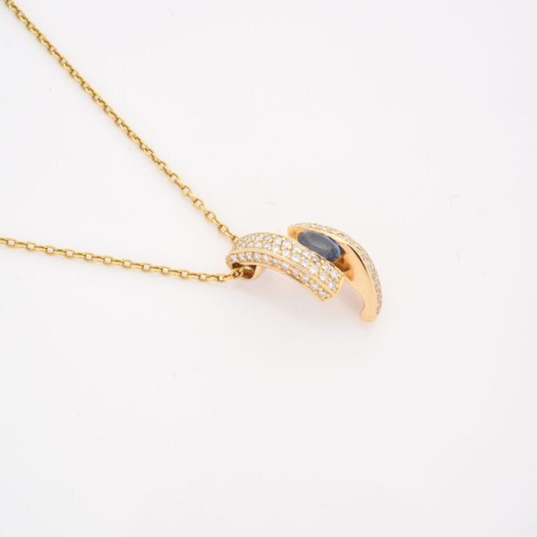 Chaîne en or jaune (750) à maille forçat retenant un pendentif asymétrique cent…