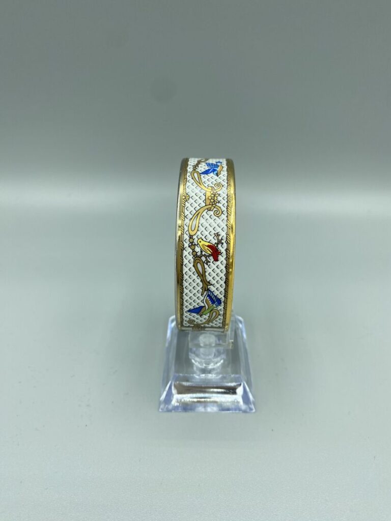 HERMÈS Paris - Bracelet jonc en métal doré à décor émaillé polychrome de volati…