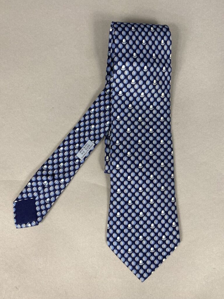 HERMÈS Paris - Lot de deux cravates en soie à motifs stylisés sur fond marine o…