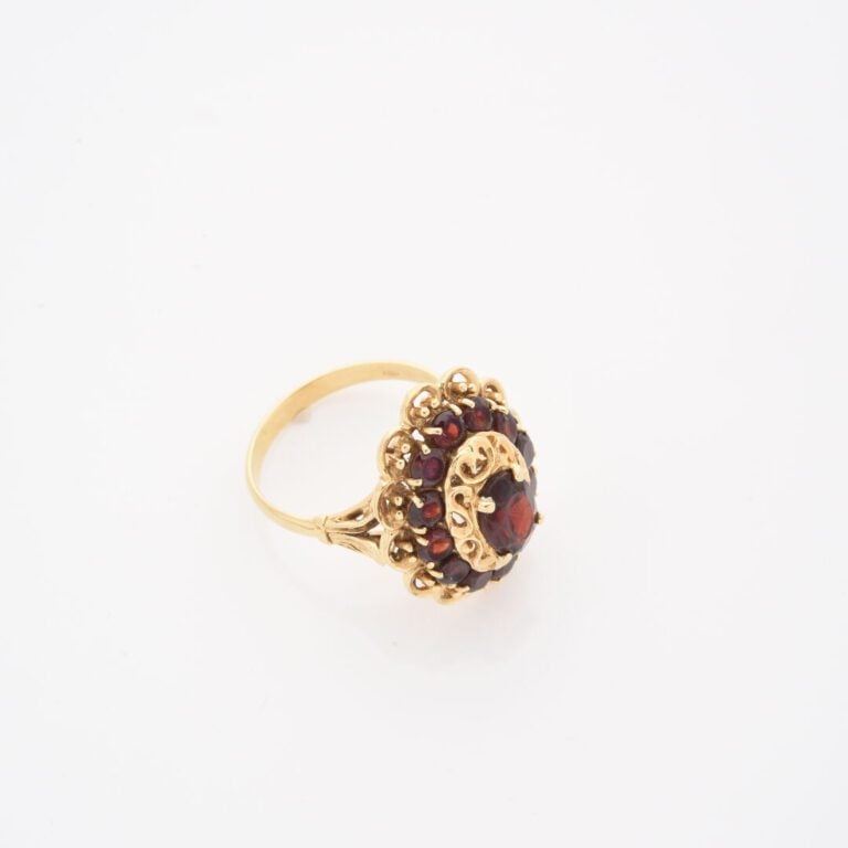 Importante bague en or jaune (750) à chaton polylobé ajouré, centrée d'un grena…