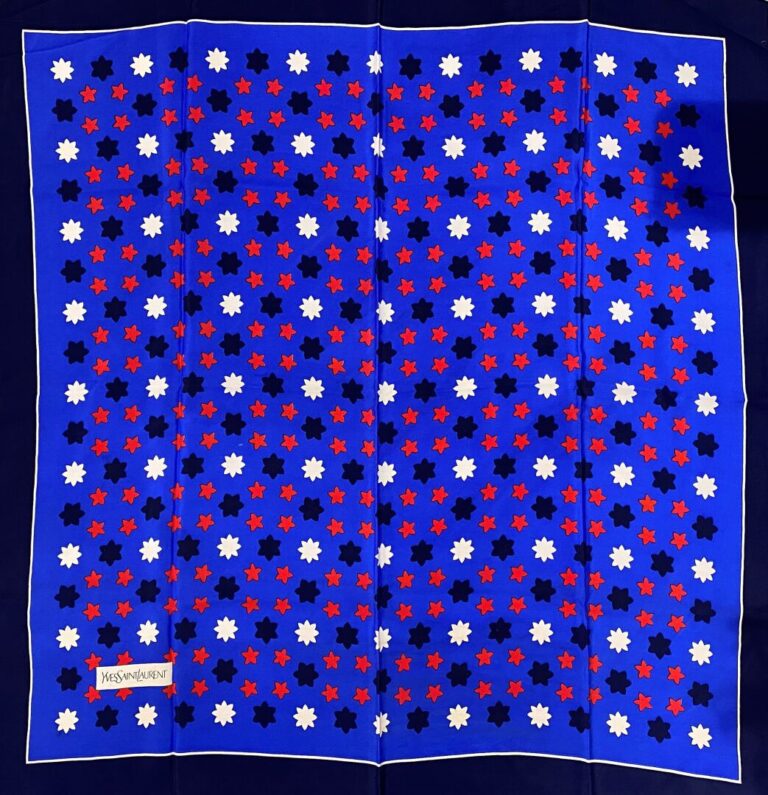 Yves SAINT LAURENT - Carré en soie à motif de semis étoilé sur fond bleu, bordu…