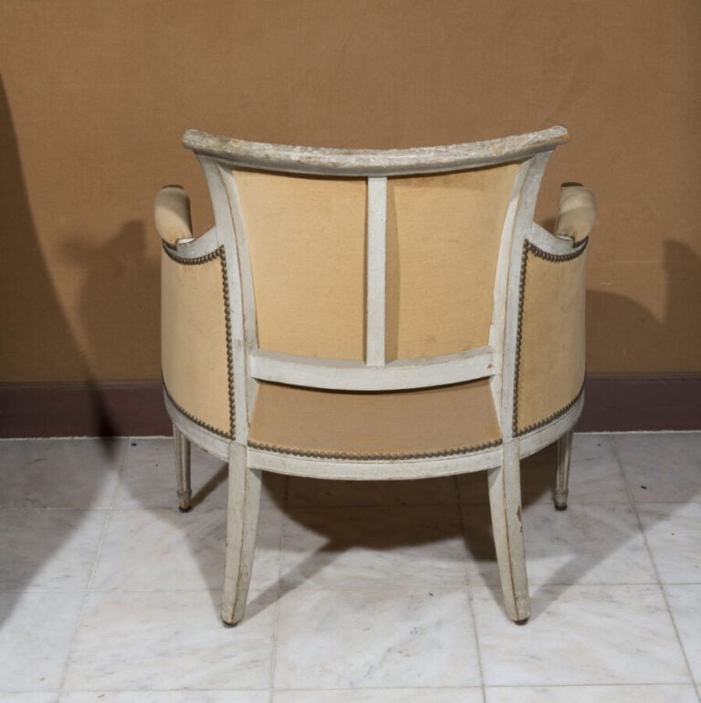 Bergère à dossier renversé en bois relaqué beige. Accotoirs à colonnettes. . Ep…