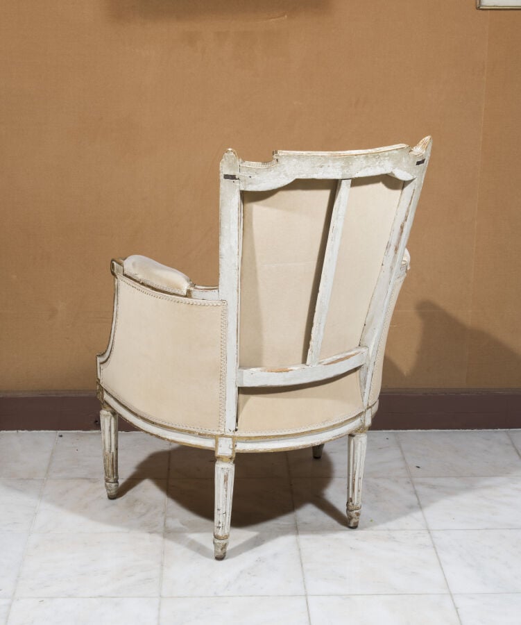 Bergère à dossier renversé en bois relaqué beige. Accotoirs à colonnettes. . Ep…