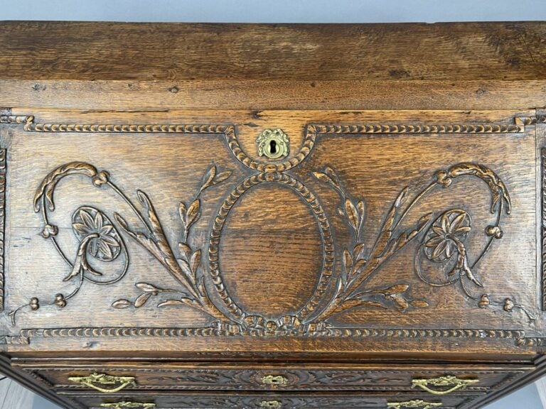 Bureau de pente en chêne mouluré et sculpté à décor de médaillon, frises et rin…
