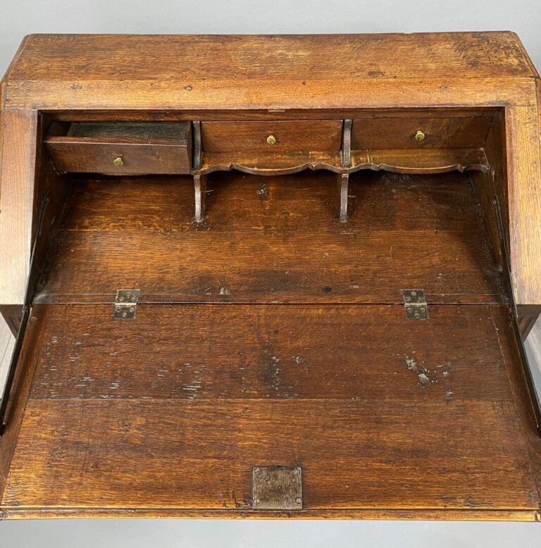 Bureau de pente en chêne mouluré et sculpté à décor de médaillon, frises et rin…